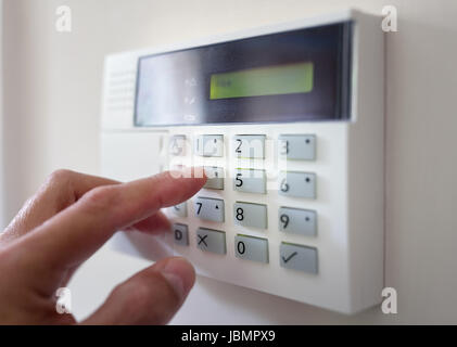 Security alarm keypad with person arming the system concept for crime prevention Stock Photo