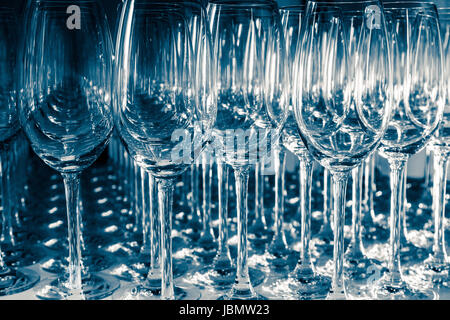 Many Empty Wineglasses Upside Down on a White reflective Table Stock Photo