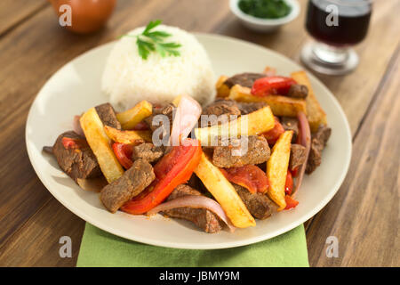 Peruvian dish called Lomo Saltado made of beef, tomato, red onion and French fries, served with rice (Selective Focus, Focus one third into the dish) Stock Photo