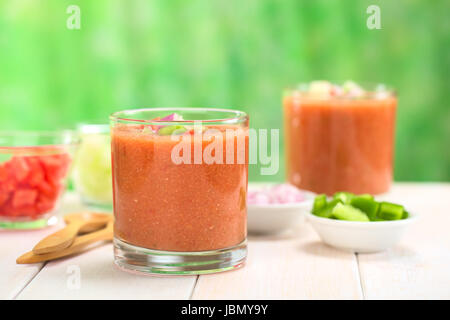 Traditional Spanish cold vegetable soup made of tomato, cucumber, bell pepper, onion, garlic and olive oil served in glasses (Selective Focus, Focus on the front of the glass rim) Stock Photo