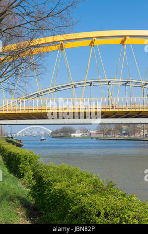 yellow arch bridge in Utrecht, netherlands. The Hogeweide Bridge is a steel arch bridge over the Amsterdam-Rhine Canal Stock Photo