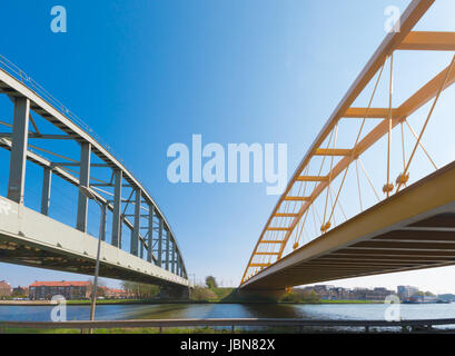 railroad bridge and yellow arch bridge in Utrecht, netherlands. The yellow Hogeweide Bridge is a steel arch bridge over the Amsterdam-Rhine Canal Stock Photo