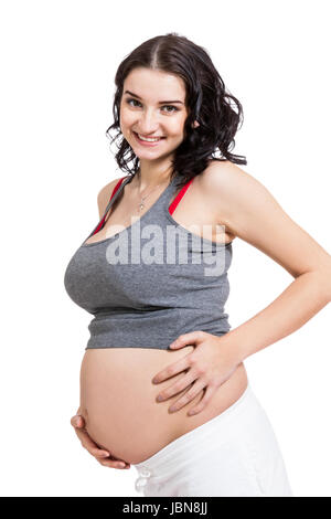 Junge frau mit Babybauch in erwartungsvoller Haltung als Nahaufnahme isoliert vor weißem Hintergrund Stock Photo