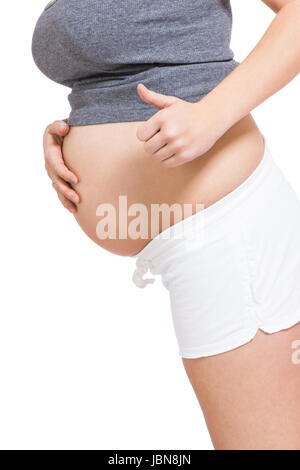 Junge frau mit Babybauch in erwartungsvoller Haltung als Nahaufnahme isoliert vor weißem Hintergrund Stock Photo