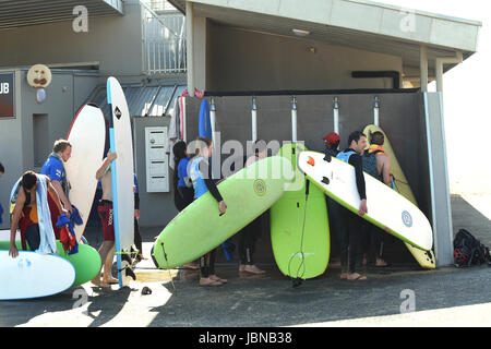Surfers washing their surf boards after leaving Capbreton beach in South Western France Stock Photo
