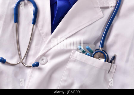 Close up white gown doctor with stethoscope pills and pen in pocket. Horizontal composition. Front view Stock Photo