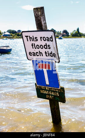 Notice: 'This road floods each tide', Bosham, a coastal village, Chichester Harbour on the south coast, Chichester district of West Sussex, UK Stock Photo