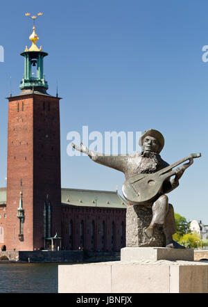 Stockholm, Sweden - Evert Taube statue with cityhall in the background - Riddarholmen Stock Photo