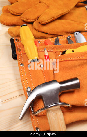 Hammer, pliers, red pencil, work gloves and other tools isolated on a wooden background Stock Photo