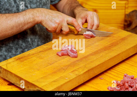 Chef Cutting Raw Meat on The Wood Block. chef cuts meat Stock Photo