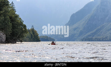 Bohinj, Slovenia - June 2, 2017: Tourists rowing on a canoe on Bohinj lake in Slovenia Stock Photo