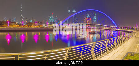 Dubai - The evening skyline with the arched bridge over the new Canal and Downtown. Stock Photo