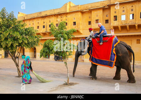 Decorated elephant with tourist walking in Jaleb Chowk (main courtyard) in Amber Fort, Rajasthan, India. Elephant rides are popular tourist attraction Stock Photo