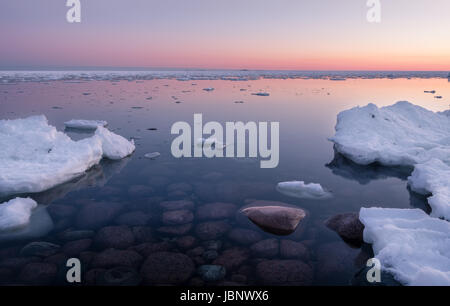 Scenic seascape with sunset and nice stones under the water at winter time Stock Photo