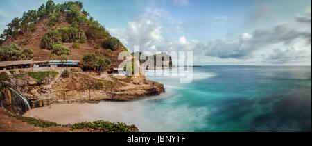 Unique seascape image of Pantai Banyu Tibu beach in East Java, Indonesia where fresh spring water tumbles onto a small cove of a white sand beach Stock Photo