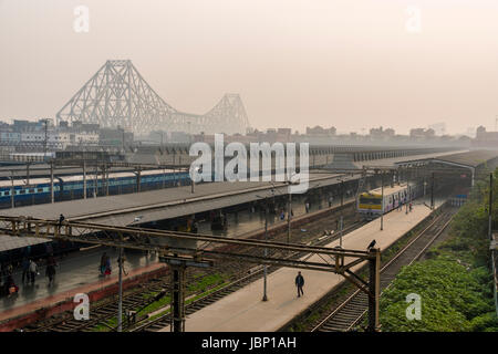 Howrah Railway Station with the the steel construction of Howrah Bridge in the hazy distance Stock Photo