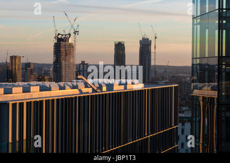 Details of office and apartment buildings against London skyline in sunset with high rise building construction work and cranes Stock Photo