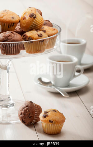 tray of little muffins variety on wooden table whit cups of coffee Stock Photo