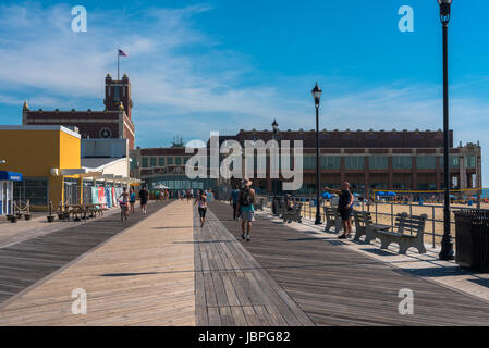 Asbury Park, NJ USA -- June 11, 2017   People walking and bicycling on the boardwalk by Convention Hall in Asbury Park on a summer morning. Editorial  Stock Photo