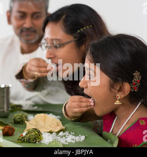 Indian family dining at home. Candid photo of Asian people eating rice with hands. India culture. Stock Photo