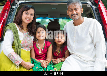 Happy Asian Indian family sitting in car, ready to summer vacation. Stock Photo