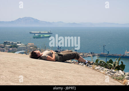 Strait of Gibraltar and middle aged woman tourist resting on the Rock of Gibraltar. Stock Photo