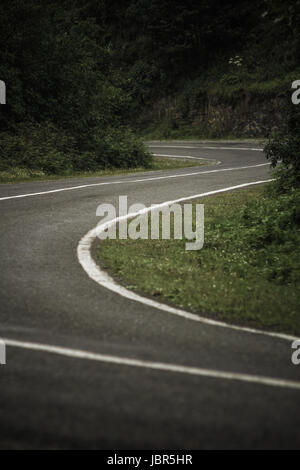 View of a curvy mountain road with a green landscape Stock Photo