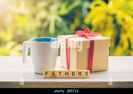 Happy fathre’s day concept coffee cup and gift box on wood table with sunlight. Stock Photo