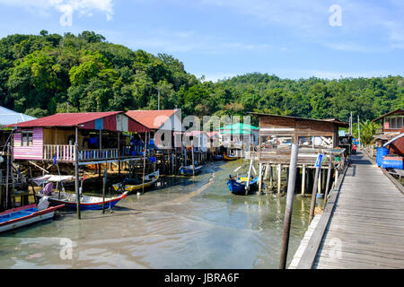 Houses on stilts, fishing boats and jetty at a fishing village on Pangkor Island (Pulau Pangkor), Malaysia. Stock Photo