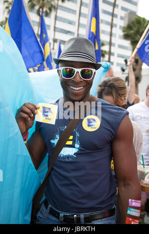 Los Angeles, California, USA. 11th June, 2017.  Daniel Ball of the Human Rights Campaign shows the sticker that says 'Resist' that he is handing out to participants at the L.A. Pride #ResistMarch in Los Angeles, Califormia on June 11th, 2017. Credit:  Sheri Determan/Alamy Live News Stock Photo