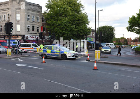 London, UK. 12th June 2017. Police tape off Aberconway Road opposite the Morden tube station. Orange traffic coins placed around the closed road to help police divert traffic away from the closed road. Credit: ZEN - Zaneta Razaite/Alamy Live News Stock Photo