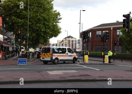 Police cordon off the road opposite the Morden tube station. Stock Photo