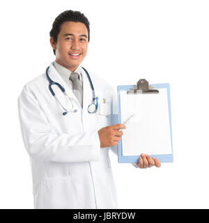 Portrait of southeast Asian male medical doctor showing and pointing to a blank empty clip file with space , standing isolated on white background. Young man model. Stock Photo