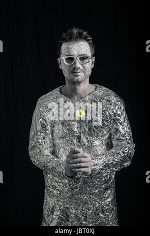 Portrait of happy spaceman holding flower. Stock Photo