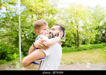 Young father with little son in green sunny nature. Stock Photo