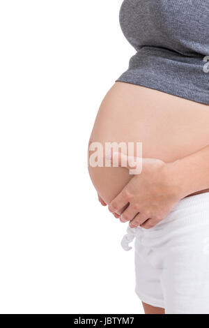 Junge frau mit Babybauch in erwartungsvoller Haltung als Nahaufnahme isoliert vor weißem Hintergrund Stock Photo