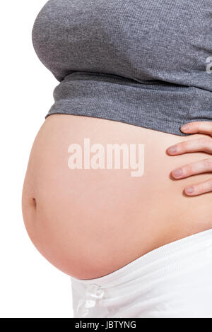 Junge frau mit Babybauch in erwartungsvoller Haltung als Nahaufnahme isoliert vor weißem Hintergrund Stock Photo