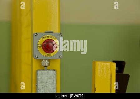 Red Emergency Stop Switch with yellow circle Stock Photo