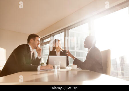 Multiracial businesspeople discussing idea, new business projects at conference table, multi-ethnic business group joking having fun, friendly atmosph Stock Photo