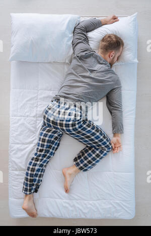 Nice adult man sleeping on his belly Stock Photo
