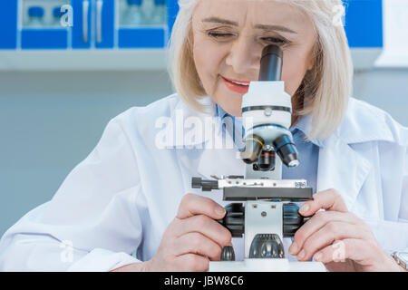 smiling senior chemists with microscope in laboratory Stock Photo