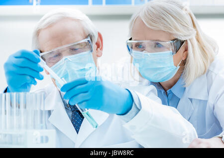 senior chemists looking at test tubes in laboratory Stock Photo