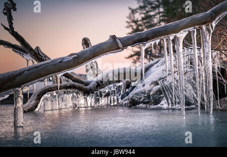 Scenic landscape with icicles and lake at the winter evening Stock Photo