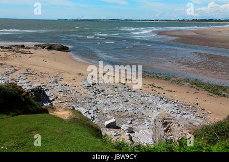 A view across the mouth of the River Ogmore looking out towards the town of Porthcawl with sandy beaches and blue waters. Stock Photo