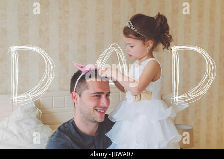 Little girl with father wearing crowns. Fathers day concept. Stock Photo