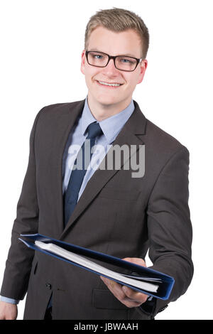 Freigestelltes Foto eines jungen, lächelnden Geschäftsmannes, der einen blauen Aktenorder übergibt. Der Mann schaut zur Kamera. Stock Photo