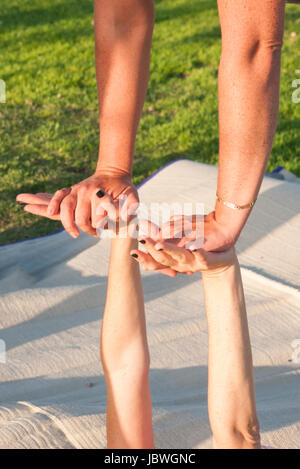 t during an Acro Yoga practice session in Charles Clore Park on the Jaffa shore, Israel Stock Photo