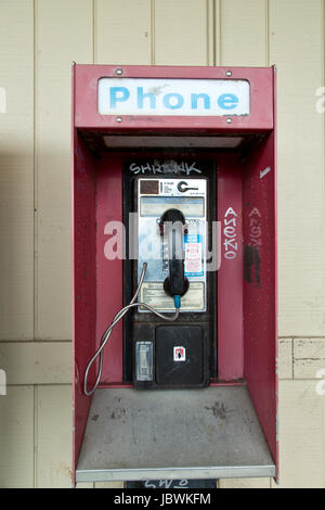 Abandoned coin operated public pay telephone with coin release slot, old shopping center. Stock Photo