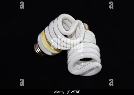 Closeup of two fluorescent light bulbs isolated on a black background. Stock Photo
