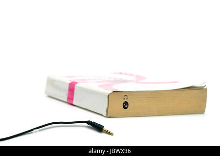 Headphones  jack on book isolated on white representing audiobook concept Stock Photo